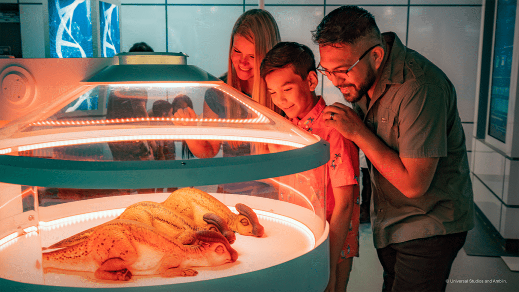 A family enjoy the Hammond Creation lab at Jurassic World: The Experience, in Manchester, getting up close with a baby dinosaur in an incubator 