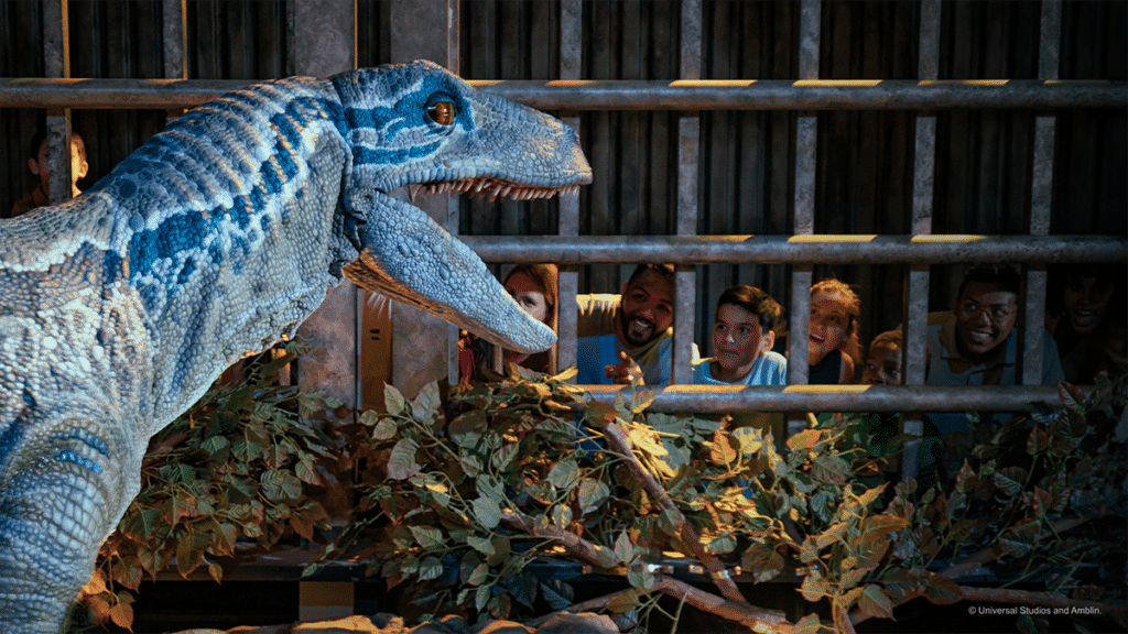 Blue the raptor roars at guests behind the bard of Jurassic World: The Experience, in Manchester