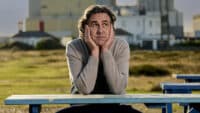 Micky Flanagan sits at a picnic table, looking morose