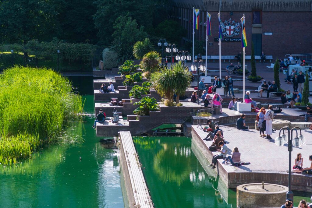 People relaxing and hanging out around the water in the Barbican Center