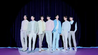 BTS Members posing in a row in front of a black background