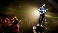 Matthew Murphy of The Wombats performs at Brixton Academy on February 22, 2012, standing on the speakers with his back to a thrilled crowd