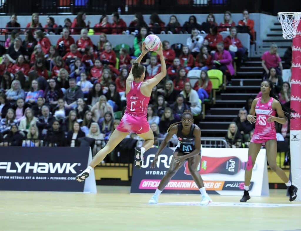 A player for the London Lions basketball team jumping to take a shot, while two other players watch