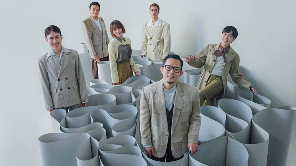 The members of Sodagreen standing in a load of curly paper tubes