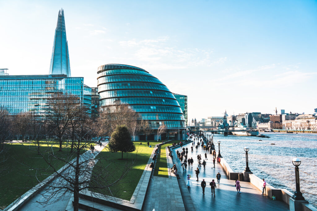 Southbank, London on a sunny day with people walking along a pathway next to the Thames