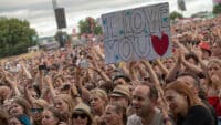 Festival-goers at TRNSMT hold up a sign reading "I love you"