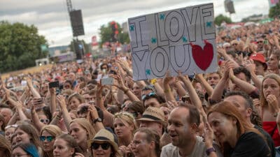 Festival-goers at TRNSMT hold up a sign reading "I love you"