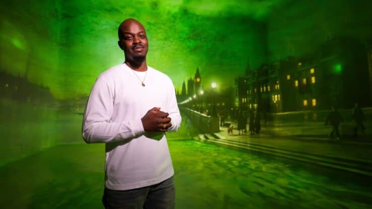 George The Poet stands in front of a digital painting at FRAMELESS