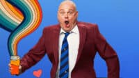 Al Murray, dressed as The Pub Landlord, holds a pint of beer that's emitting rays of cartoon rainbow colours