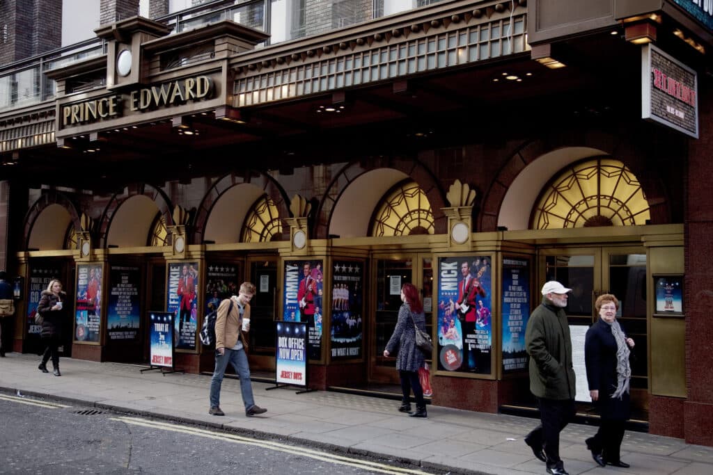 People passing by outside the Prince Edward Theatre on Old Compton Street, Soho