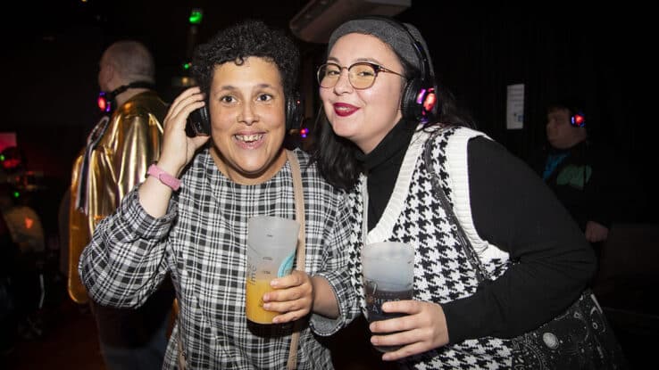 Two women pose for a photo at a silent disco event