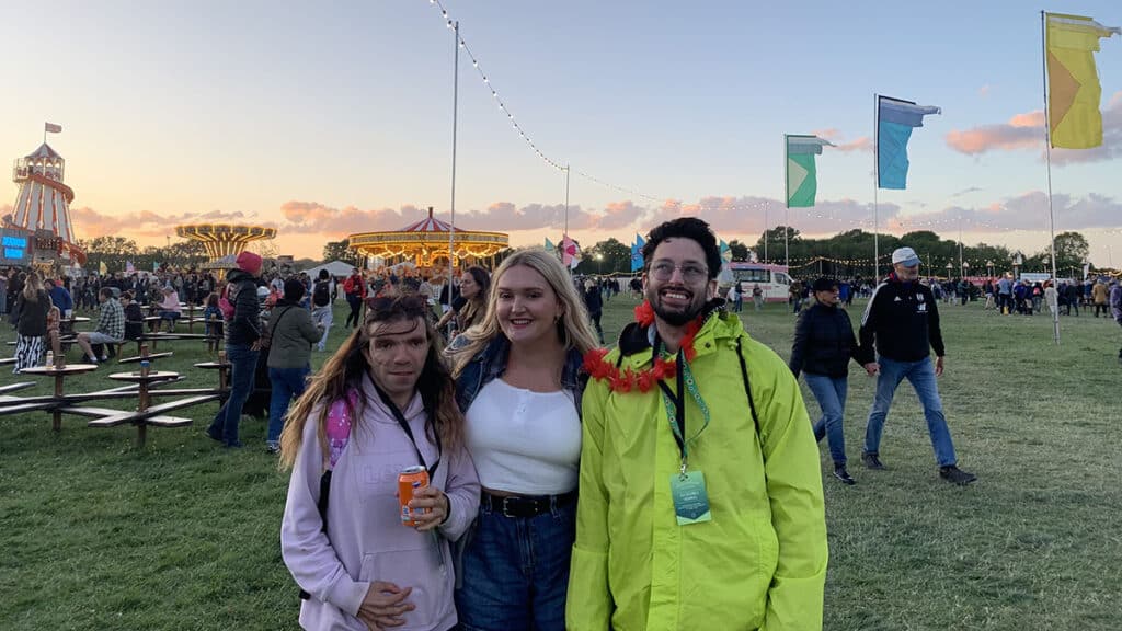 Three friends pose for a photo at a music festival