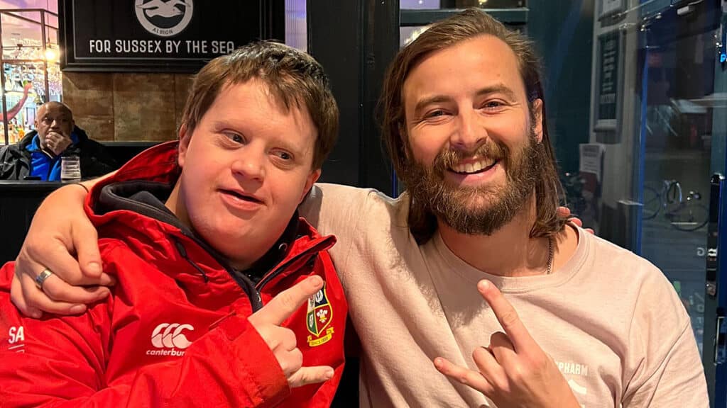 Two men pose with "devil horns" finger signs in a Brighton pub