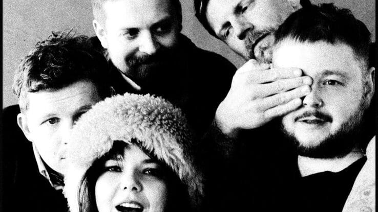 The members of Of Monsters And Men crowd into the photo frame