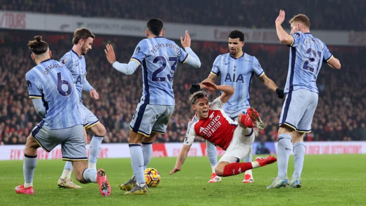 LONDON, ENGLAND - JANUARY 15: Leandro Trossard of Arsenal is surrounded by Tottenham players as he goes down after a challenge during the Premier League match between Arsenal FC and Tottenham Hotspur FC at Emirates Stadium on January 15, 2025 in London, England. (Photo by Catherine Ivill - AMA/Getty Images)