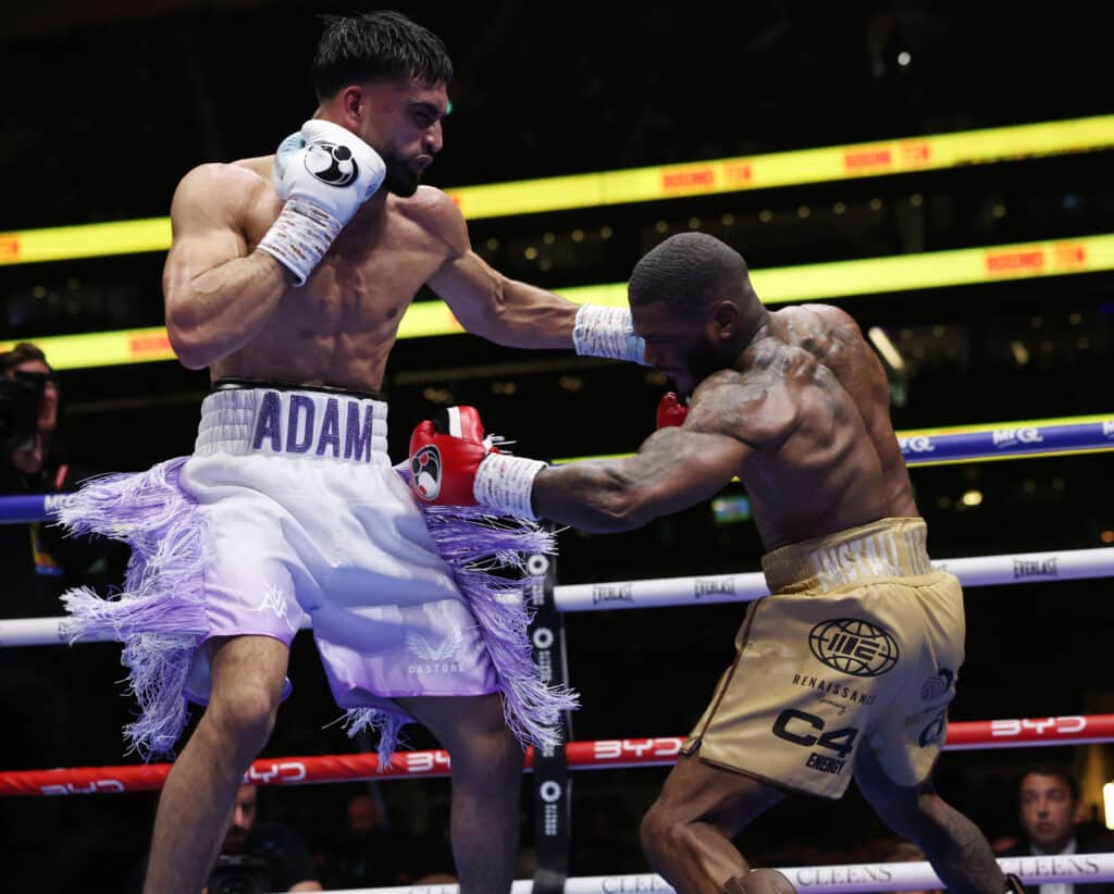 Adam Azim and Kurt Scoby throwing punches during a boxing match