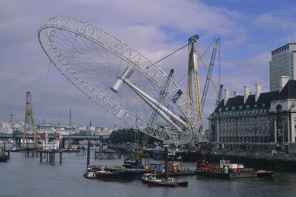 The rim of the London Eye being hoisted into an upright position during construction