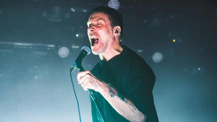 Sleaford Mods' frontman Jason Williamson on stage.