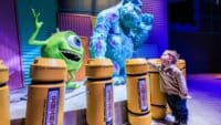 child posing with Mike and Sully at Mundo Pixar experience