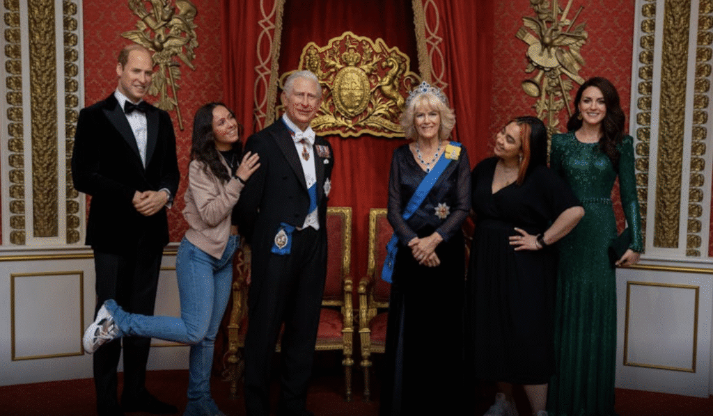 A visitor to Madame Tussauds London posing with an exhibit of the British Royal Family