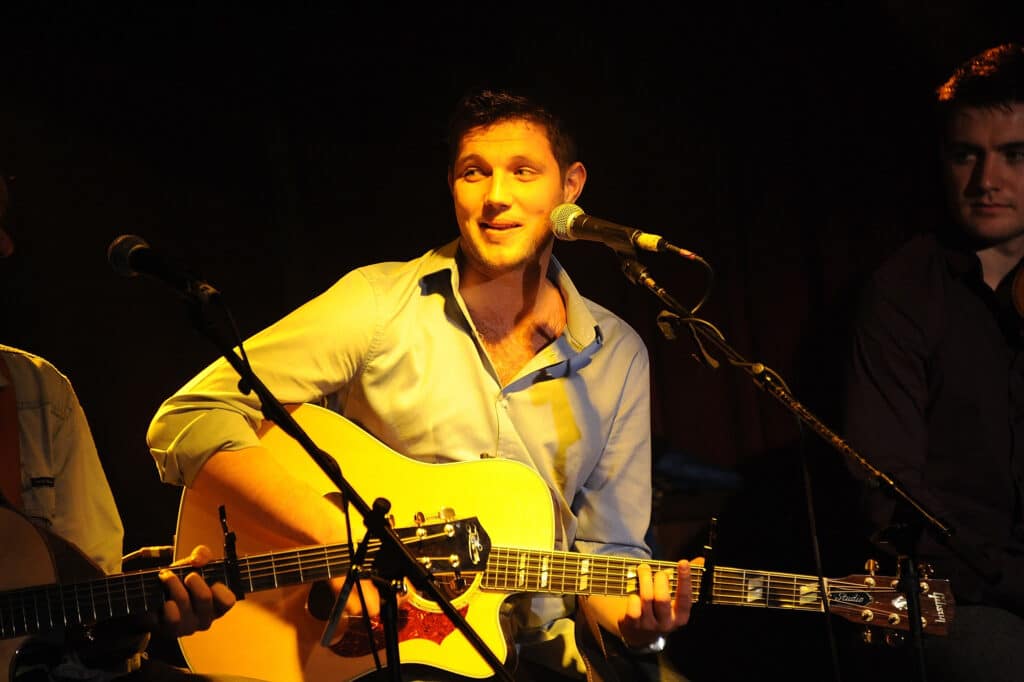 Colm Keegan playing guitar and singing while performing live onstage
