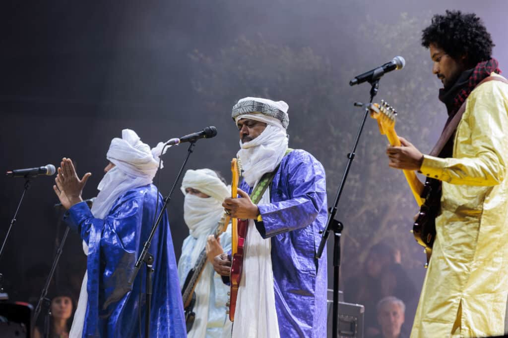 Abdallah Ag Alhousseyni of the band Tinariwen and other musicians performing live onstage