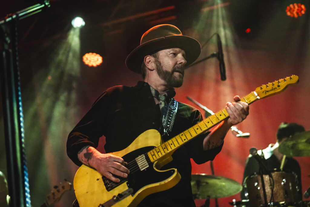 Kiefer Sutherland performing live onstage with a guitar