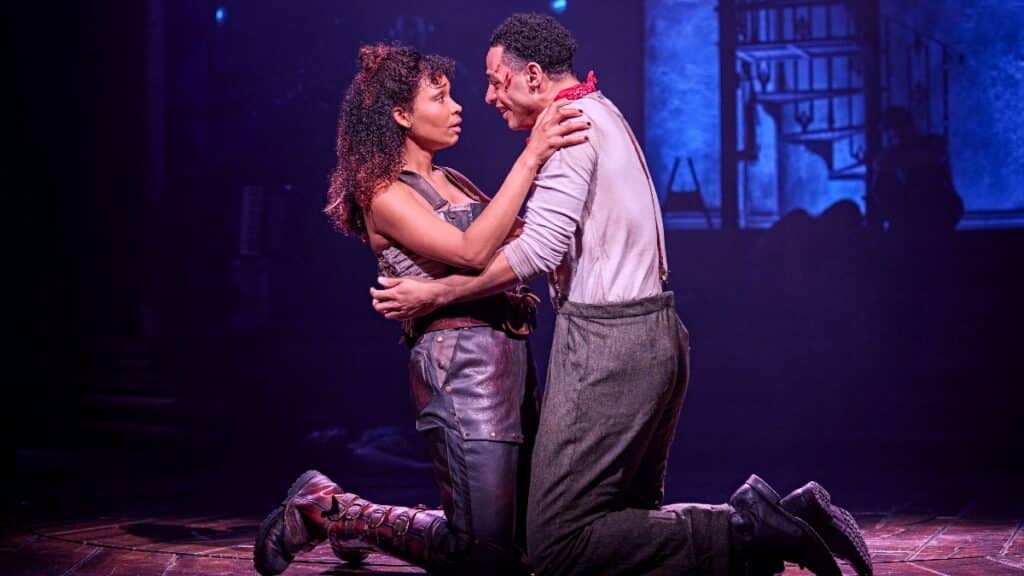 Lovers embrace on stage at Hadestown