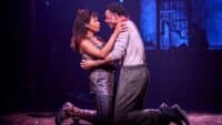 Lovers embrace on stage at Hadestown