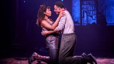 Lovers embrace on stage at Hadestown