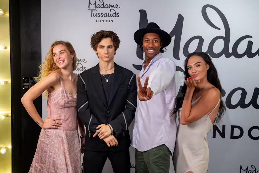 Fans pose next to a waxwork model of Timothée Chalamet at Madame Tussauds London