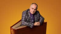 Jack Dee climbs out the pages of a large hardback book