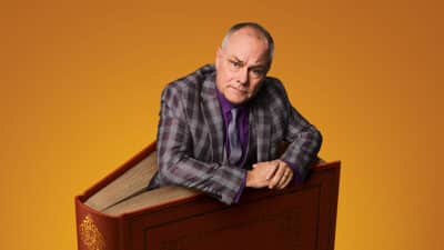 Jack Dee climbs out the pages of a large hardback book